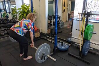 Older woman in physical therapy lifting weight